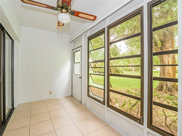 unfurnished sunroom with ceiling fan