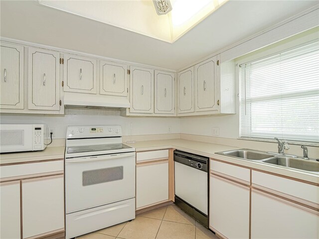 kitchen featuring white cabinets, sink, white appliances, and light tile patterned flooring