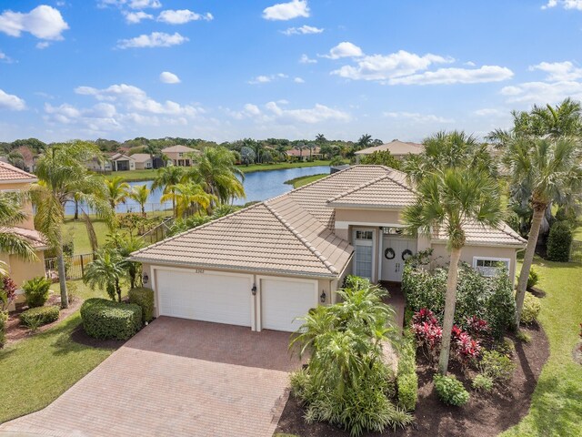 mediterranean / spanish-style home with a garage, a water view, and a front yard