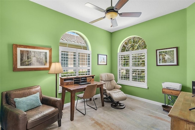 office space featuring a ceiling fan and baseboards
