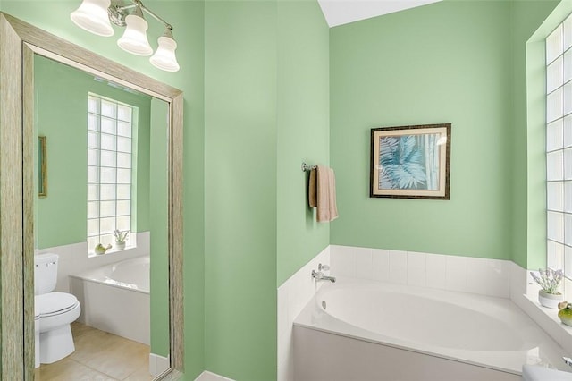 full bathroom with tile patterned floors, toilet, and a bath