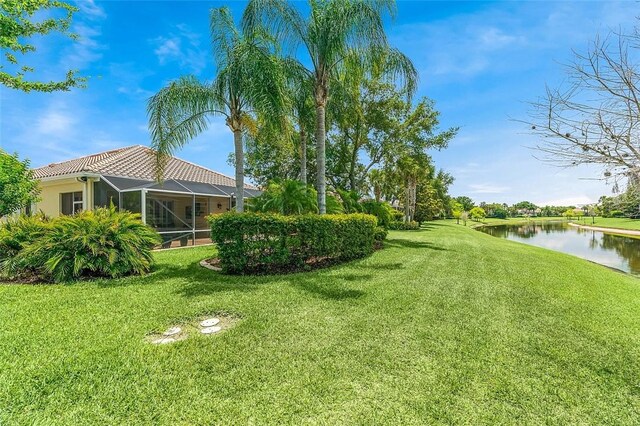 view of yard featuring a water view and a lanai