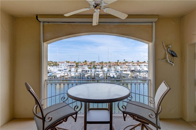 balcony featuring ceiling fan and a water view