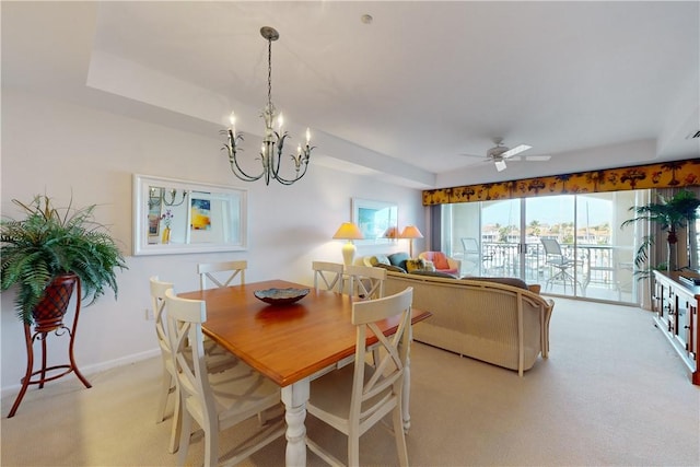 dining space with light carpet and ceiling fan with notable chandelier