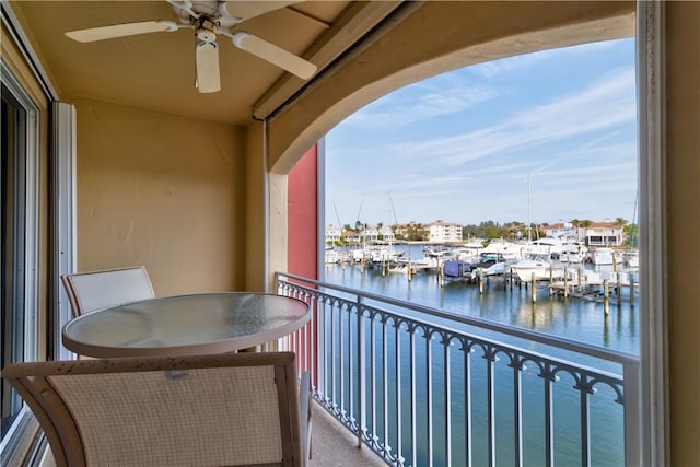 balcony with ceiling fan and a water view