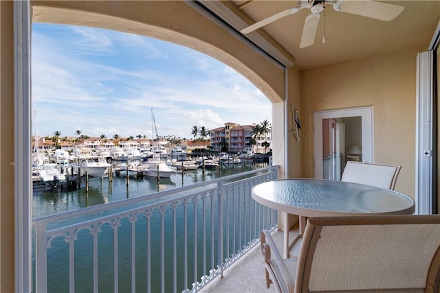 balcony with ceiling fan and a water view