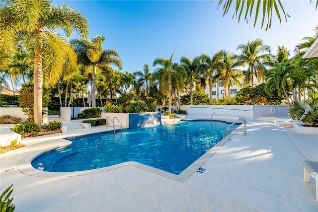 community pool with a patio and fence