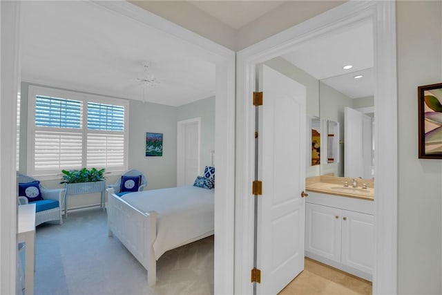 bedroom with recessed lighting, light carpet, and a sink