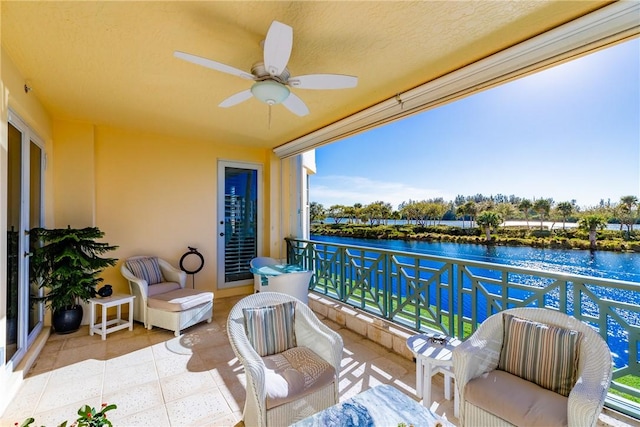 balcony featuring a water view and ceiling fan