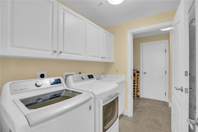 washroom with a sink, cabinet space, independent washer and dryer, and light tile patterned floors