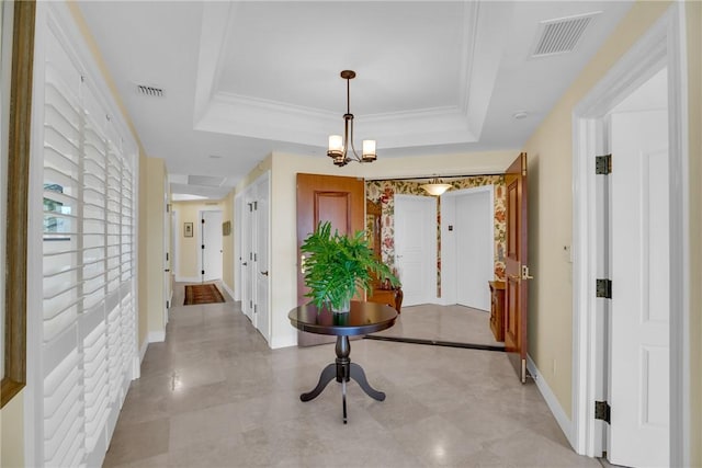 corridor featuring visible vents, a tray ceiling, and ornamental molding