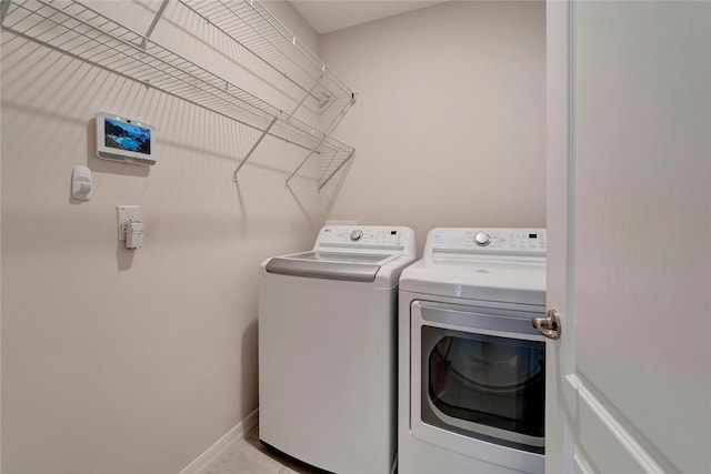 laundry area with washing machine and dryer, laundry area, and baseboards