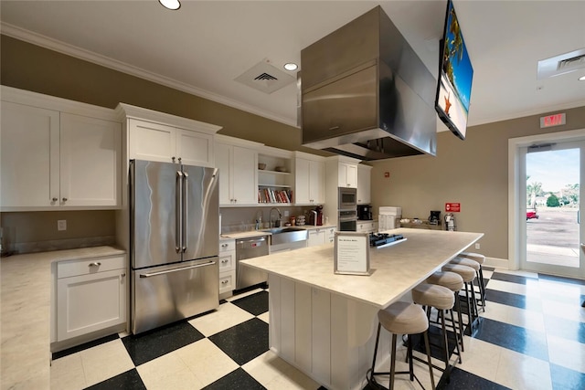 kitchen with appliances with stainless steel finishes, light countertops, crown molding, and light floors