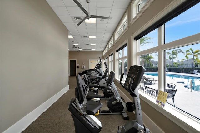 workout area with visible vents, a drop ceiling, a ceiling fan, and baseboards