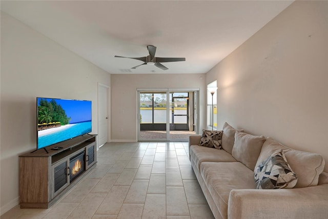 living area featuring baseboards and a ceiling fan