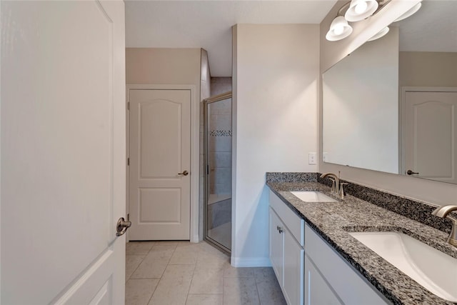 full bathroom with a sink, a shower stall, baseboards, and double vanity