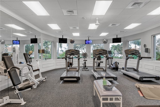 gym with a paneled ceiling, carpet flooring, and ornamental molding