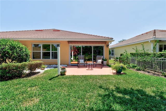 back of property featuring a lawn and a patio