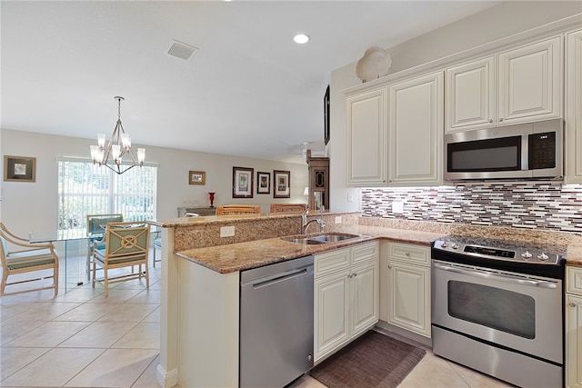 kitchen with kitchen peninsula, sink, light tile patterned floors, and stainless steel appliances