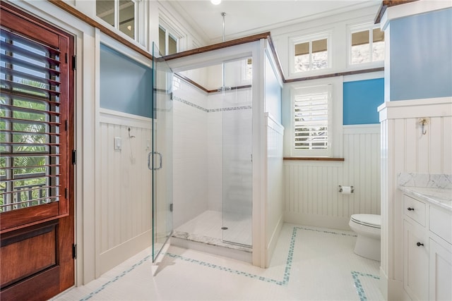 bathroom with tile patterned floors, vanity, toilet, and a shower with door