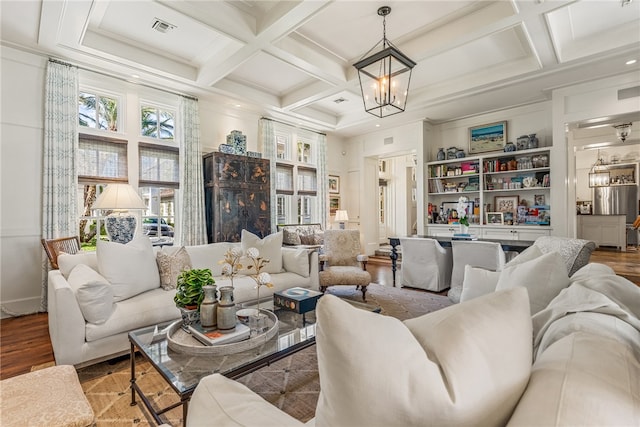 living room with hardwood / wood-style floors, an inviting chandelier, coffered ceiling, and beam ceiling