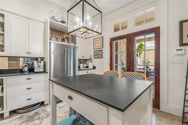 kitchen with white cabinets, french doors, backsplash, and hanging light fixtures