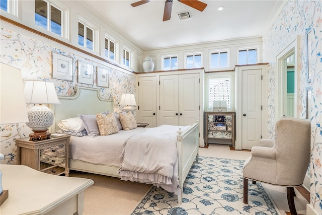 bedroom with light carpet, ceiling fan, and crown molding