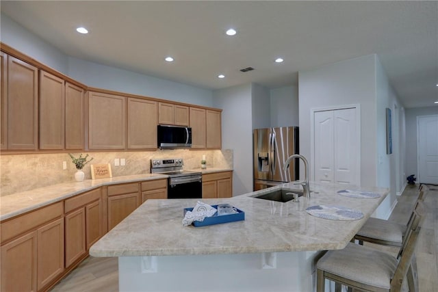 240 Barbossa Dr, Sebastian, FL 32958 - kitchen featuring appliances with stainless steel finishes, recessed lighting, a breakfast bar, light wood-type flooring, and tasteful backsplash