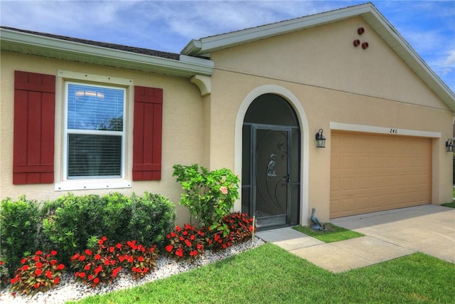 240 Barbossa Dr, Sebastian, FL 32958 - view of exterior entry featuring stucco siding, an attached garage, and driveway