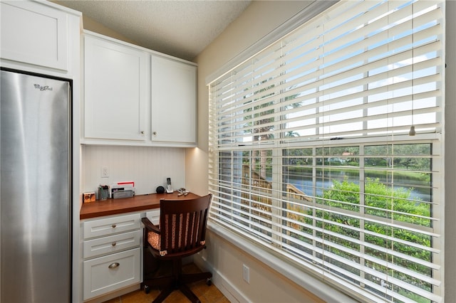 home office featuring built in desk and a textured ceiling