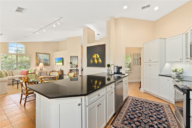 kitchen featuring appliances with stainless steel finishes, vaulted ceiling, white cabinetry, and sink