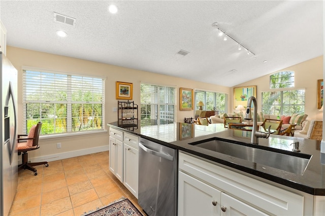 kitchen featuring lofted ceiling, white cabinets, sink, a textured ceiling, and appliances with stainless steel finishes