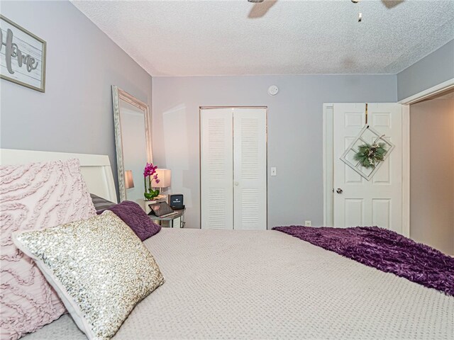 bedroom with a textured ceiling, ceiling fan, and a closet