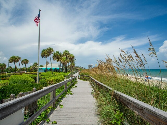 view of home's community with a water view and a beach view