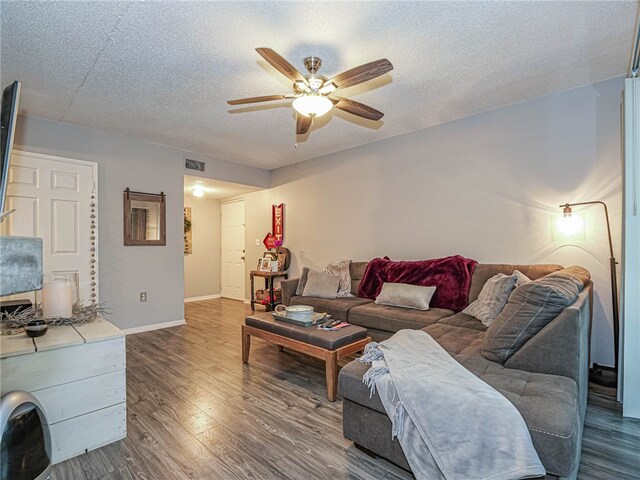 living room featuring a textured ceiling, hardwood / wood-style flooring, and ceiling fan