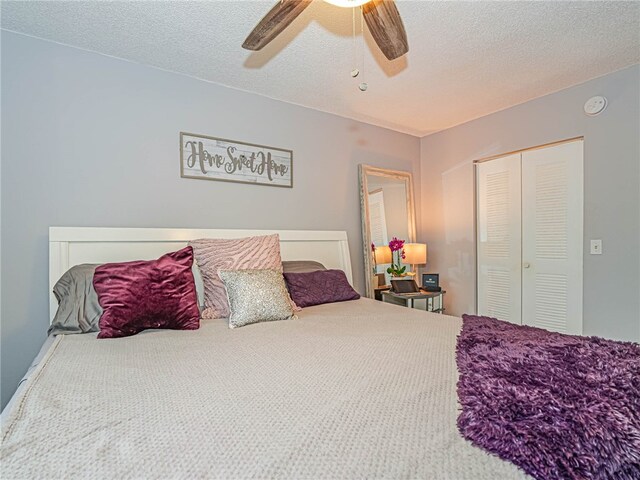 bedroom with ceiling fan, a textured ceiling, a closet, and carpet flooring