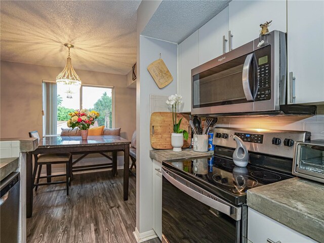 kitchen with stainless steel appliances, a textured ceiling, dark hardwood / wood-style floors, pendant lighting, and white cabinets