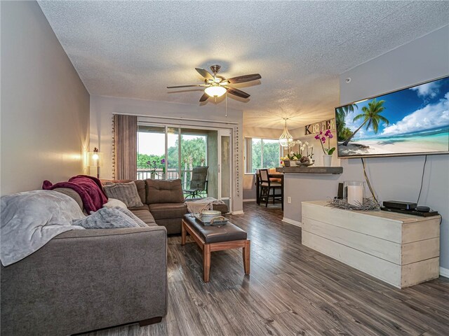 living room with dark wood-type flooring, ceiling fan, and a textured ceiling