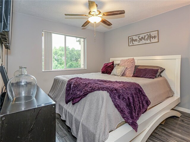 bedroom featuring a textured ceiling, hardwood / wood-style floors, and ceiling fan