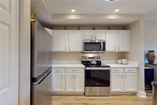 kitchen featuring white cabinetry, stainless steel appliances, and light wood-type flooring