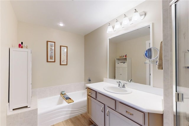 bathroom featuring hardwood / wood-style floors, vanity, and a tub