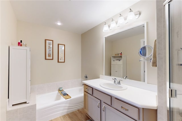 bathroom featuring a washtub, vanity, and hardwood / wood-style flooring