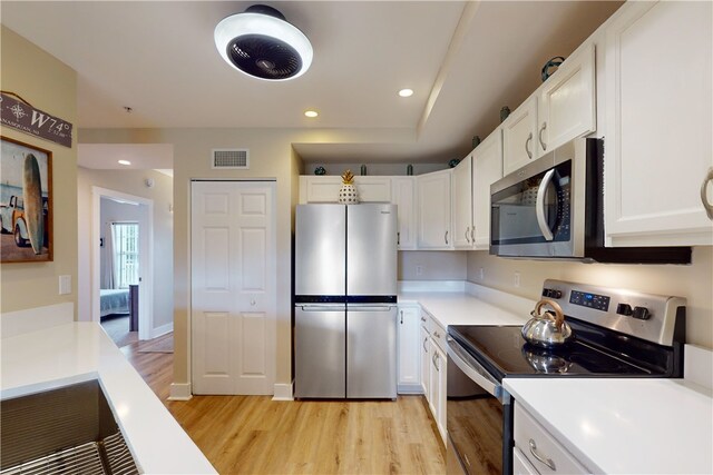 kitchen featuring white cabinets, light wood-type flooring, and stainless steel appliances