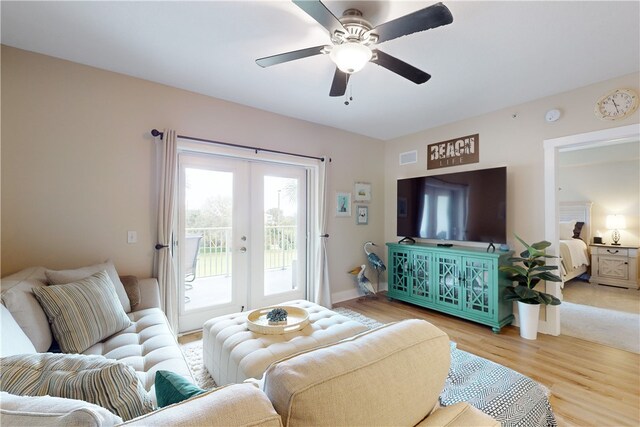 living room with hardwood / wood-style floors, ceiling fan, and french doors