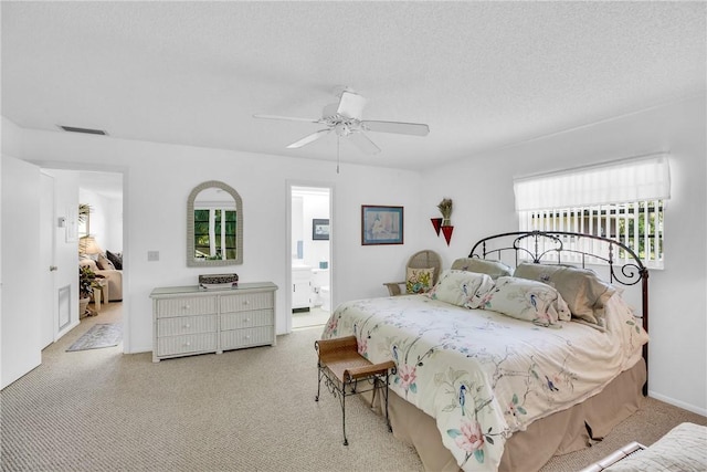bedroom featuring a textured ceiling, visible vents, carpet, connected bathroom, and ceiling fan