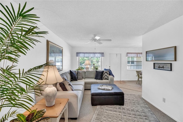 living area with a textured ceiling, carpet floors, and a ceiling fan