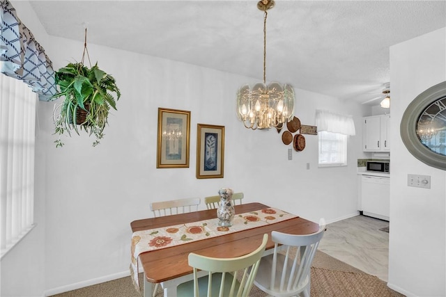 dining space with ceiling fan with notable chandelier and baseboards