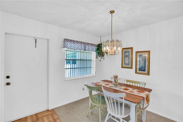 dining area featuring baseboards, a textured ceiling, and a chandelier