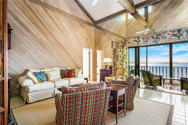 tiled living room with a water view, vaulted ceiling with beams, ceiling fan, and wooden walls