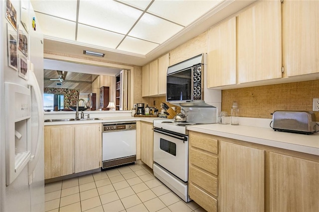 kitchen with light brown cabinetry, sink, white appliances, and light tile patterned flooring